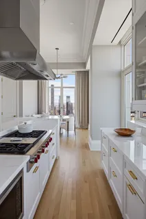 a kitchen with stainless steel appliances a stove a sink dishwasher and cabinets with wooden floor