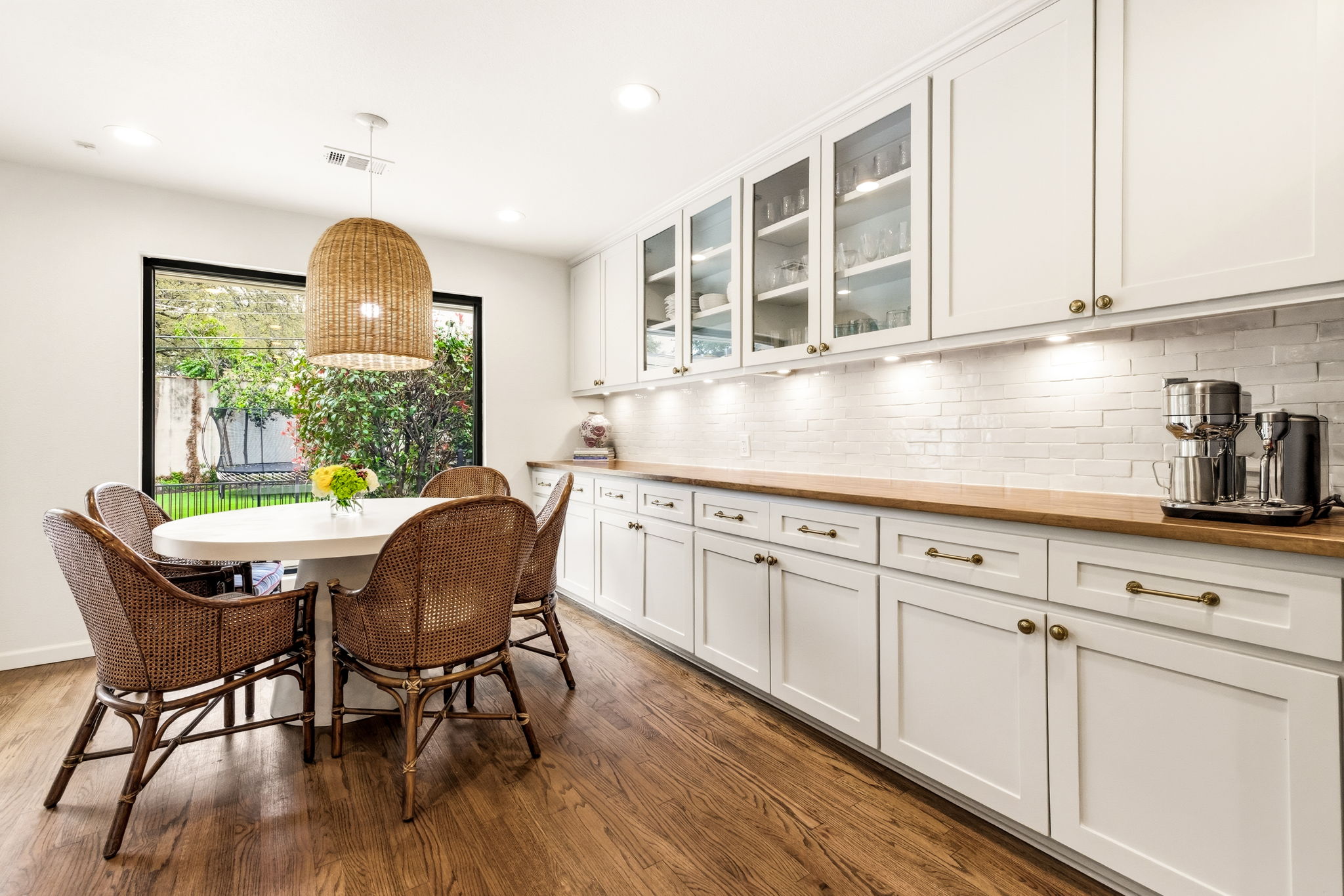 5765 Stonegate Road Dallas, TX 75209 - Photo 17 of 37 a kitchen with stainless steel appliances granite countertop a table chairs in it and white cabinets