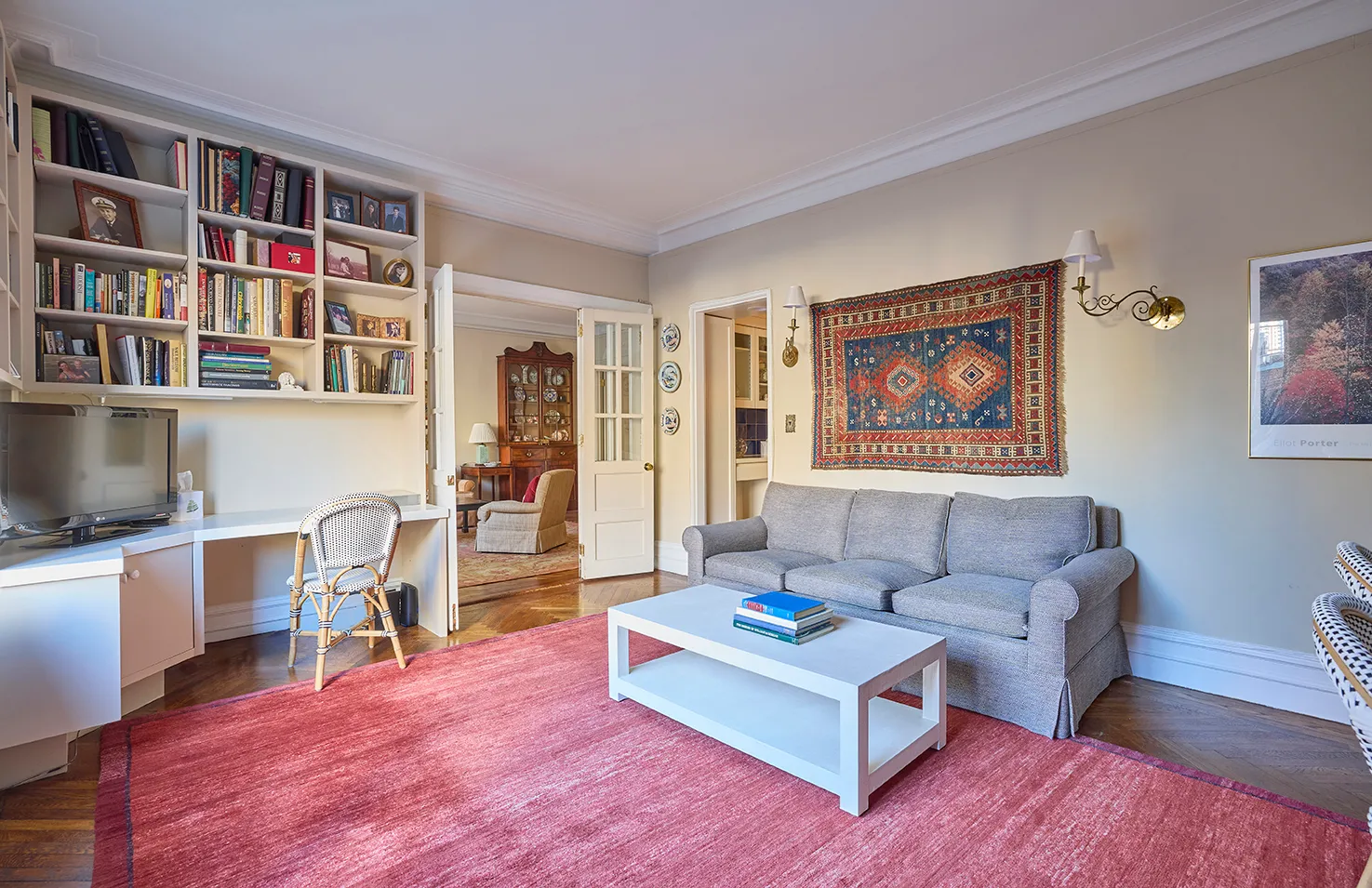 a living room with furniture and a book shelf with wooden floor