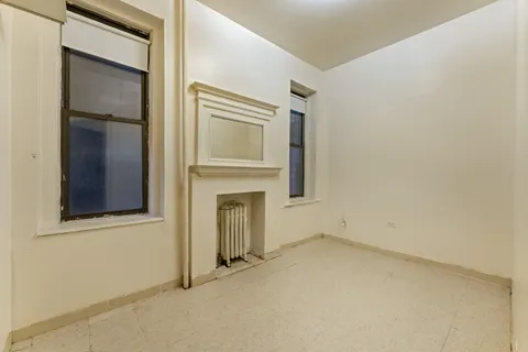 a view of an empty room with a fireplace and a window