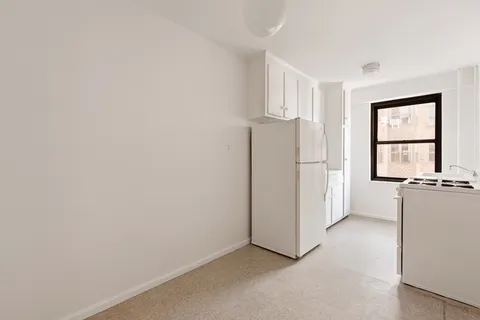 a view of a kitchen with a refrigerator a microwave and a stove top oven