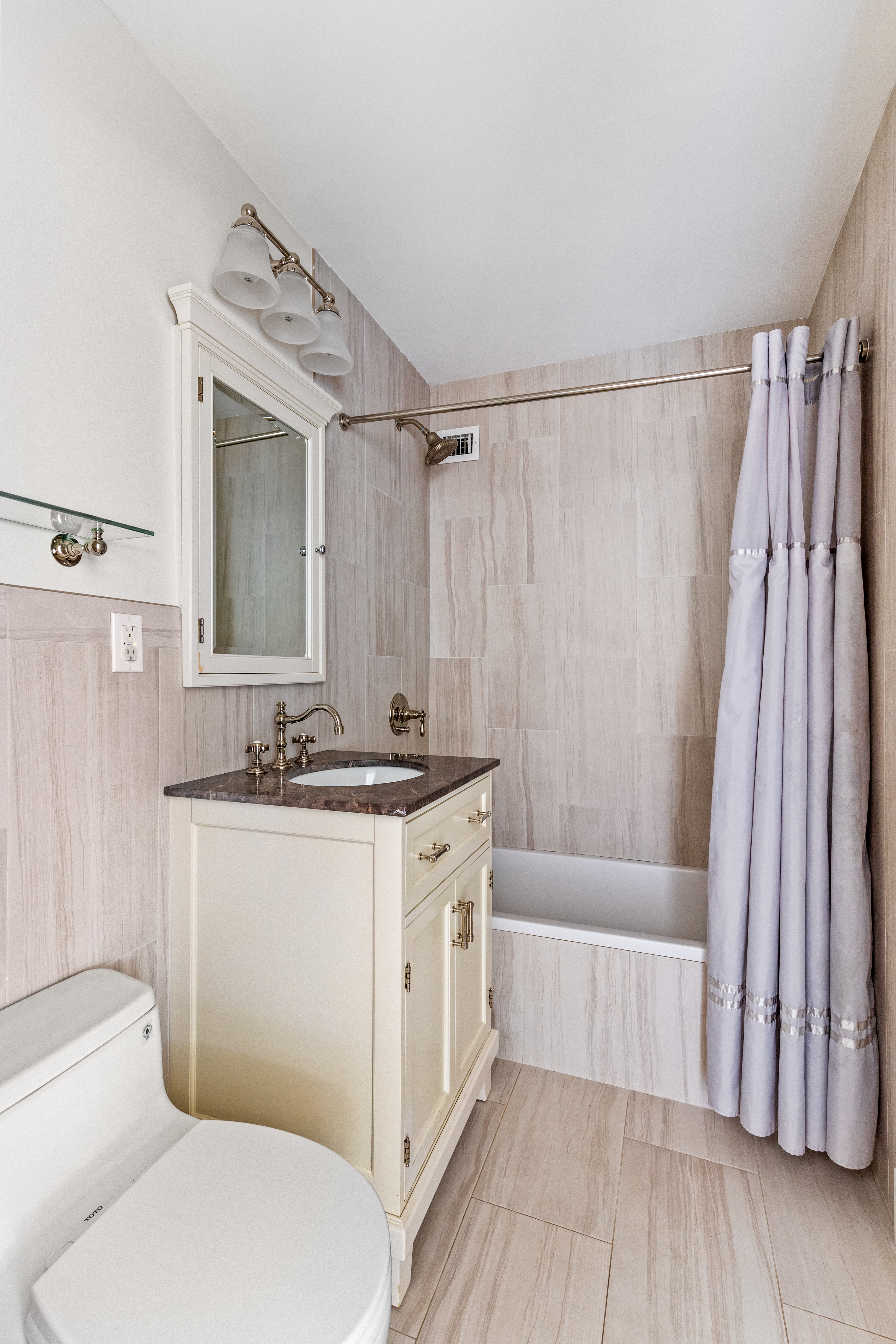 575 Main Street, Unit 1312 Manhattan, NY 10044 - Photo 16 of 25 a bathroom with a granite countertop sink toilet and shower
