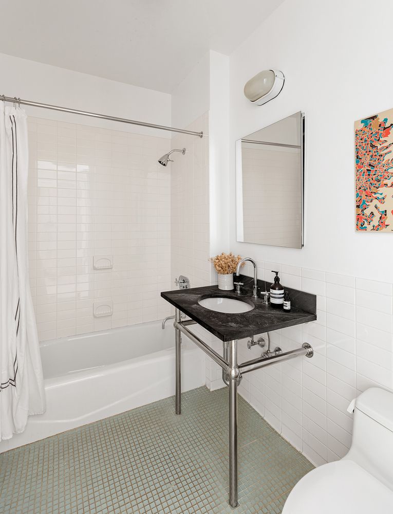 a bathroom with a sink a toilet a mirror and shower