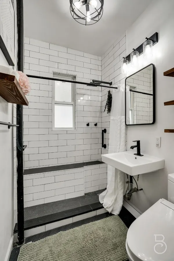 a bathroom with a sink a toilet and shower