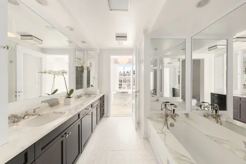 a bathroom with a double vanity sink double mirror and a bathtub