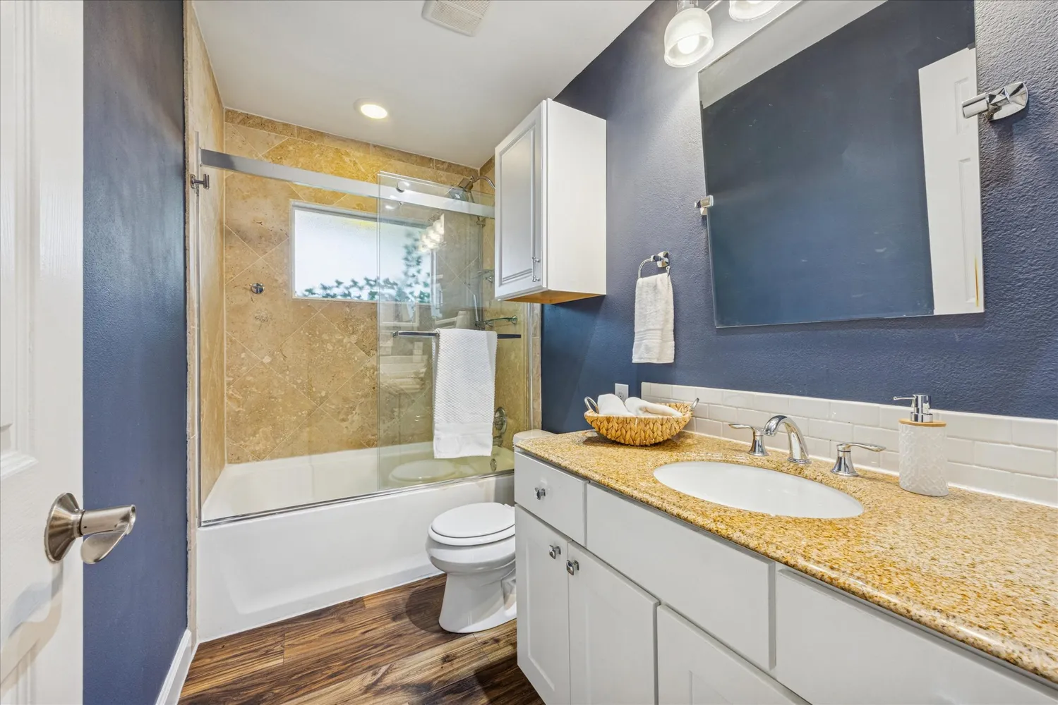 a bathroom with a granite countertop sink toilet and shower