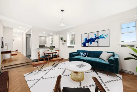 a living room with furniture and a view of kitchen
