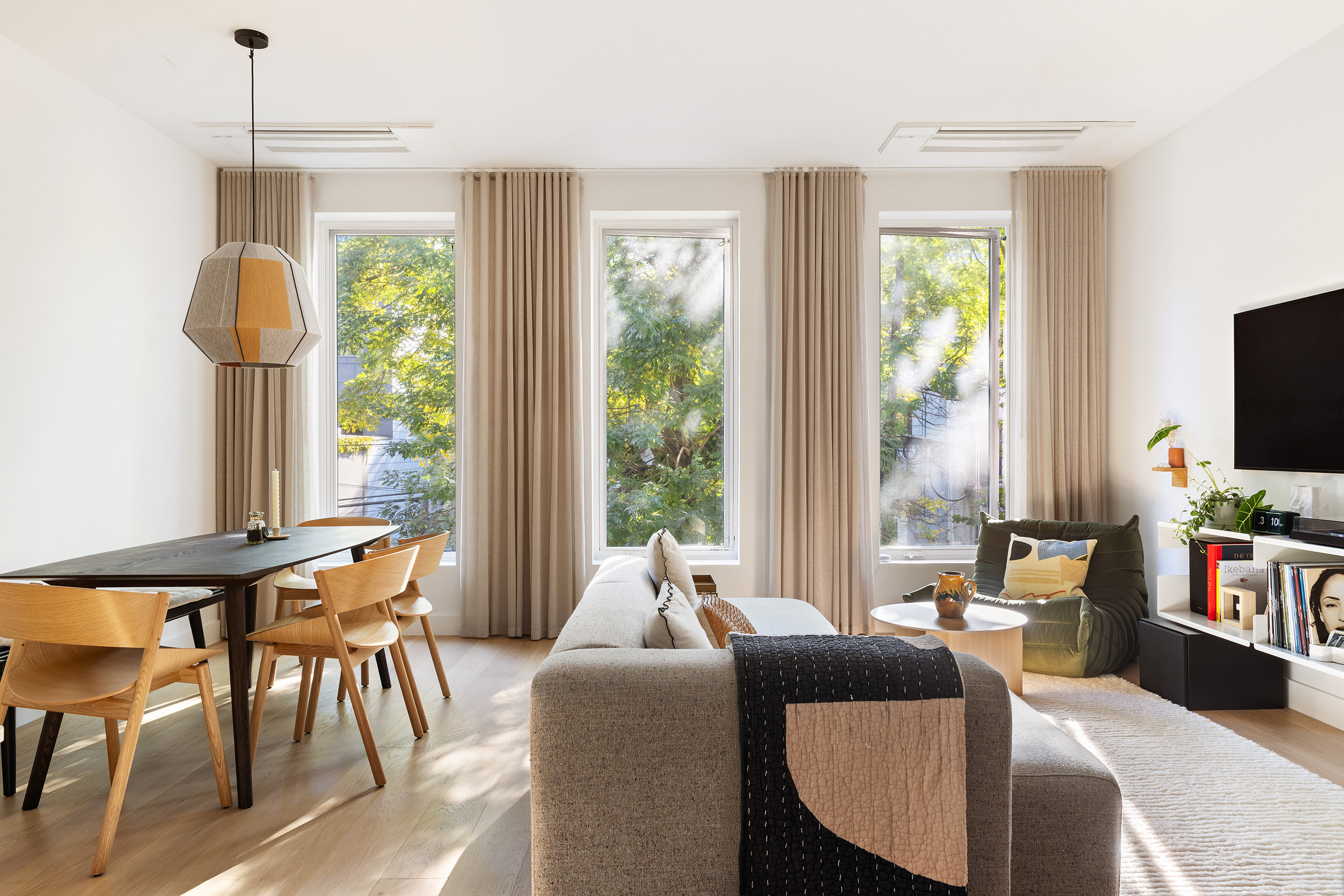 a living room with furniture a flat screen tv and a large window
