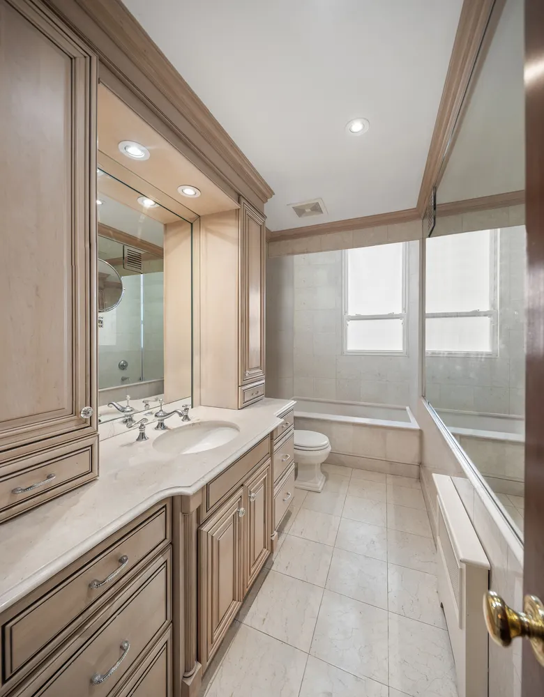 a bathroom with a granite countertop sink mirror and a large window