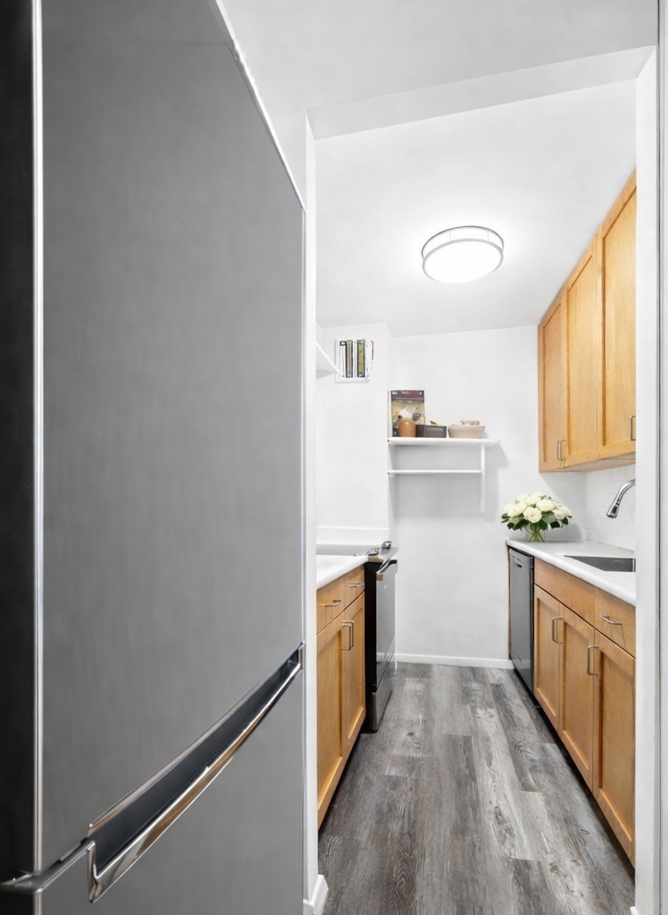 379 West Street, Unit 3B Manhattan, NY 10014 - Photo 2 of 7 a kitchen with a sink cabinets stainless steel appliances and a window