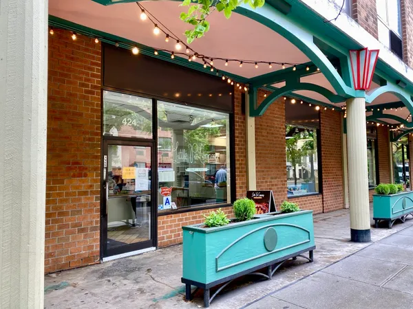 a view of a street with potted plants