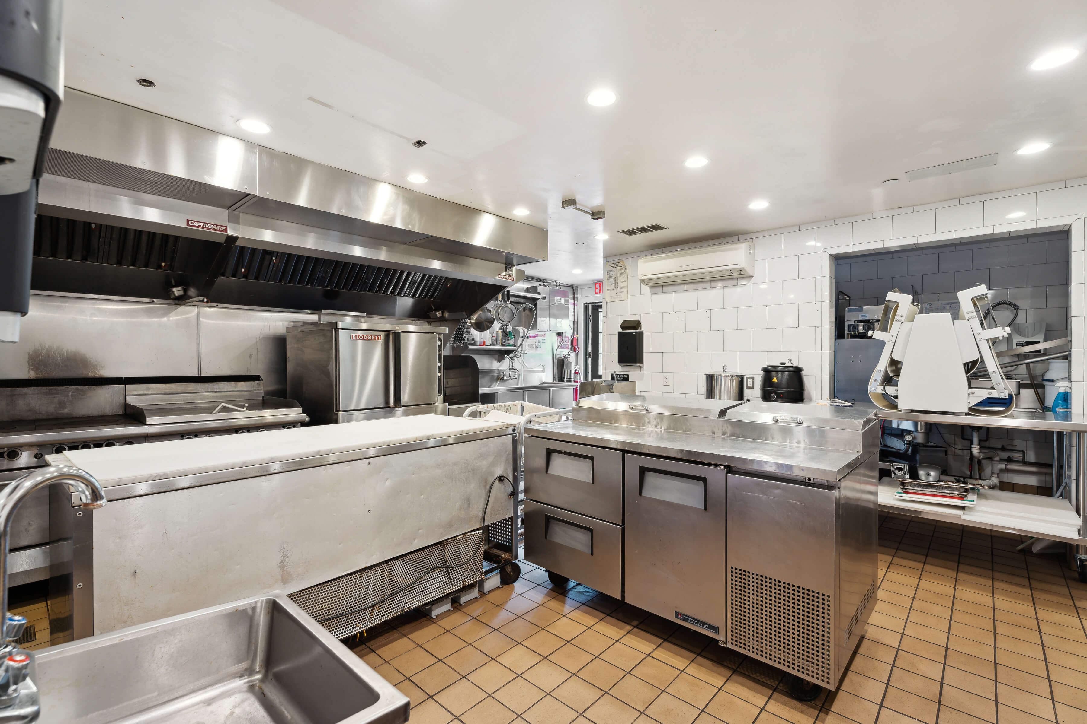 203 Bridgehampton-Sag Harbor Turnpike Bridgehampton, NY 11932 - Photo 8 of 14 a kitchen with counter top space cabinets and stainless steel appliances