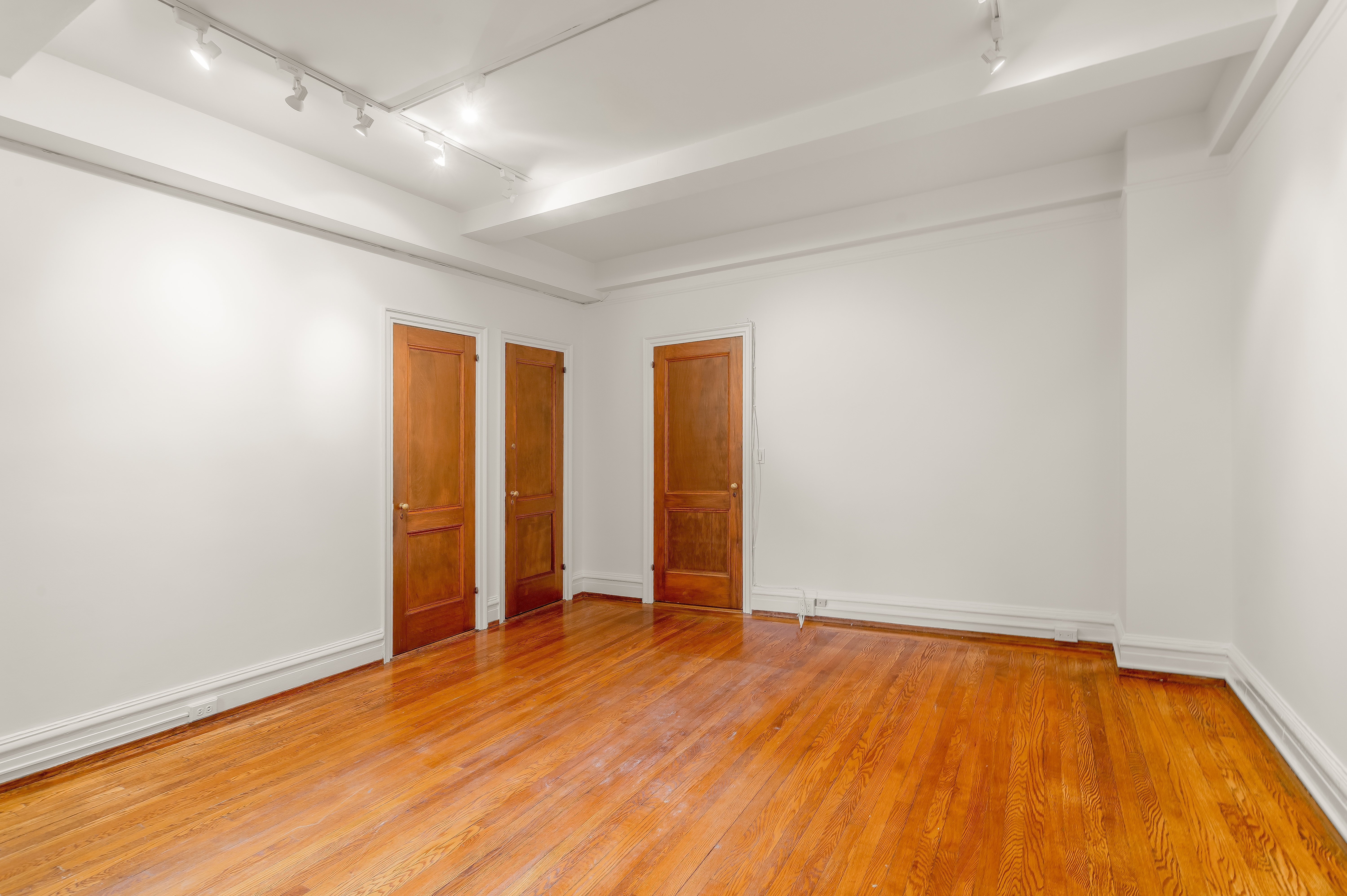 180 East 79th Street, Unit 5A Manhattan, NY 10075 - Photo 10 of 19 an empty room with wooden floor and natural light