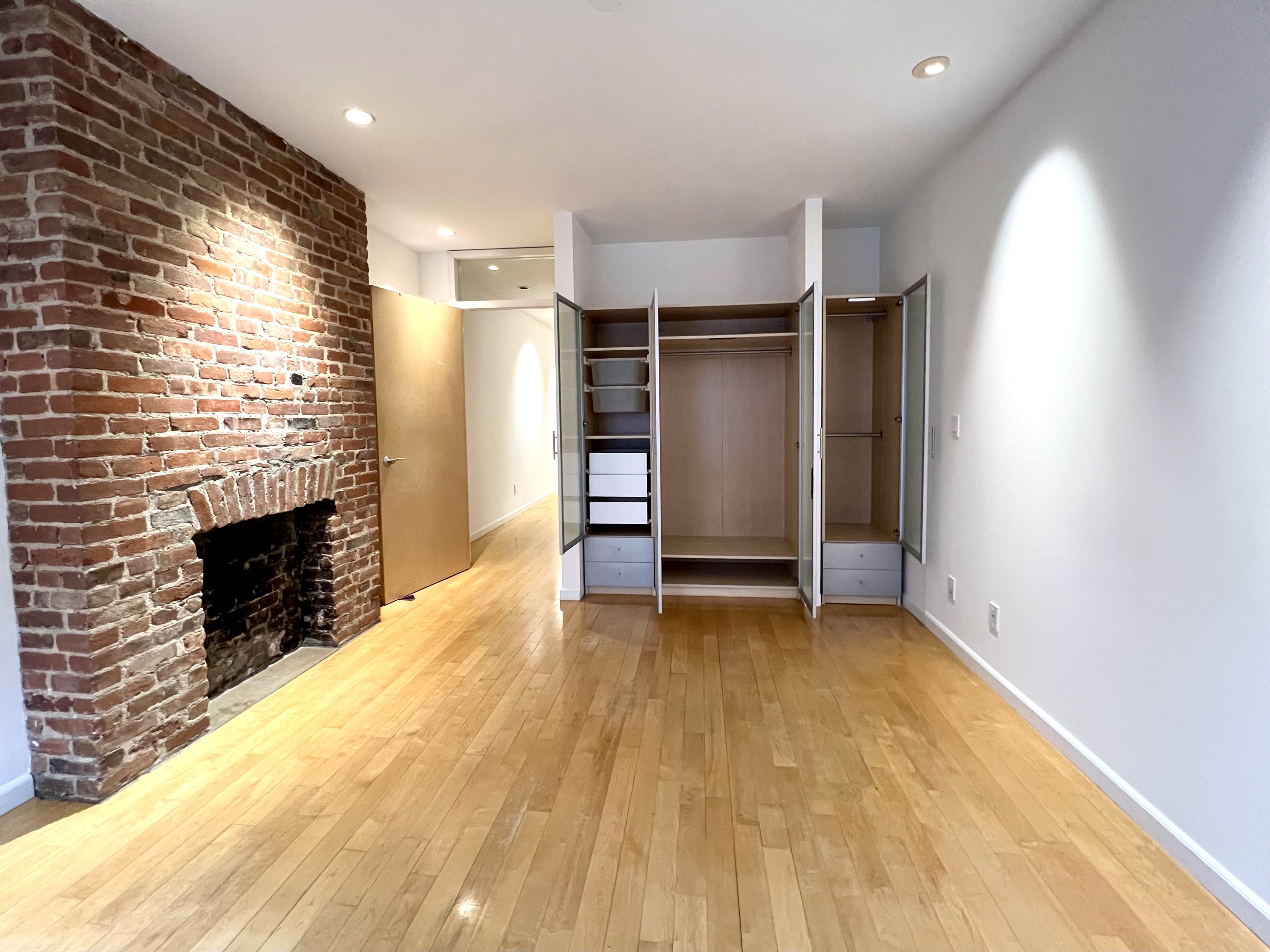 528 West 46th Street, Unit 3E Manhattan, NY 10036 - Photo 6 of 7 an empty room with a fireplace and cabinet