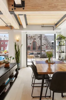 a dining room with furniture and large windows