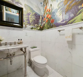 a white toilet sitting next to a bathroom sink