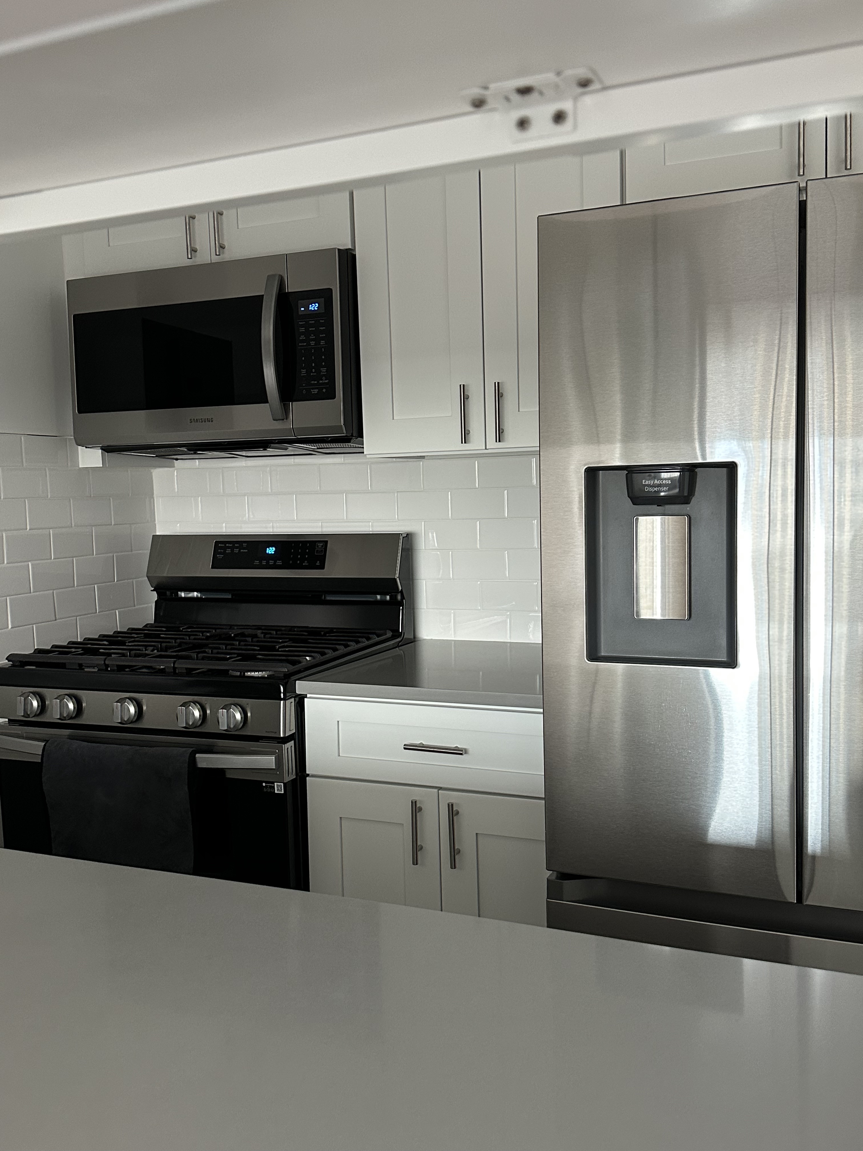 45 West 67th Street, Unit 21C Manhattan, NY 10023 - Photo 6 of 10 a kitchen with stainless steel appliances a stove a microwave and a refrigerator