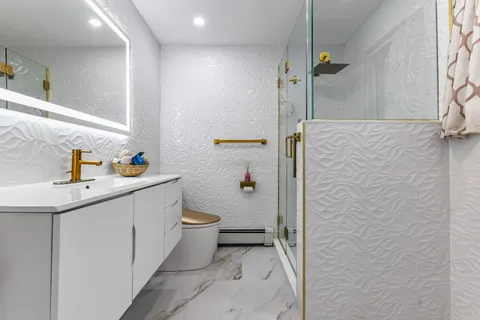 a bathroom with a sink a toilet and shower