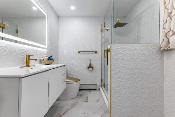 a bathroom with a sink a toilet and shower