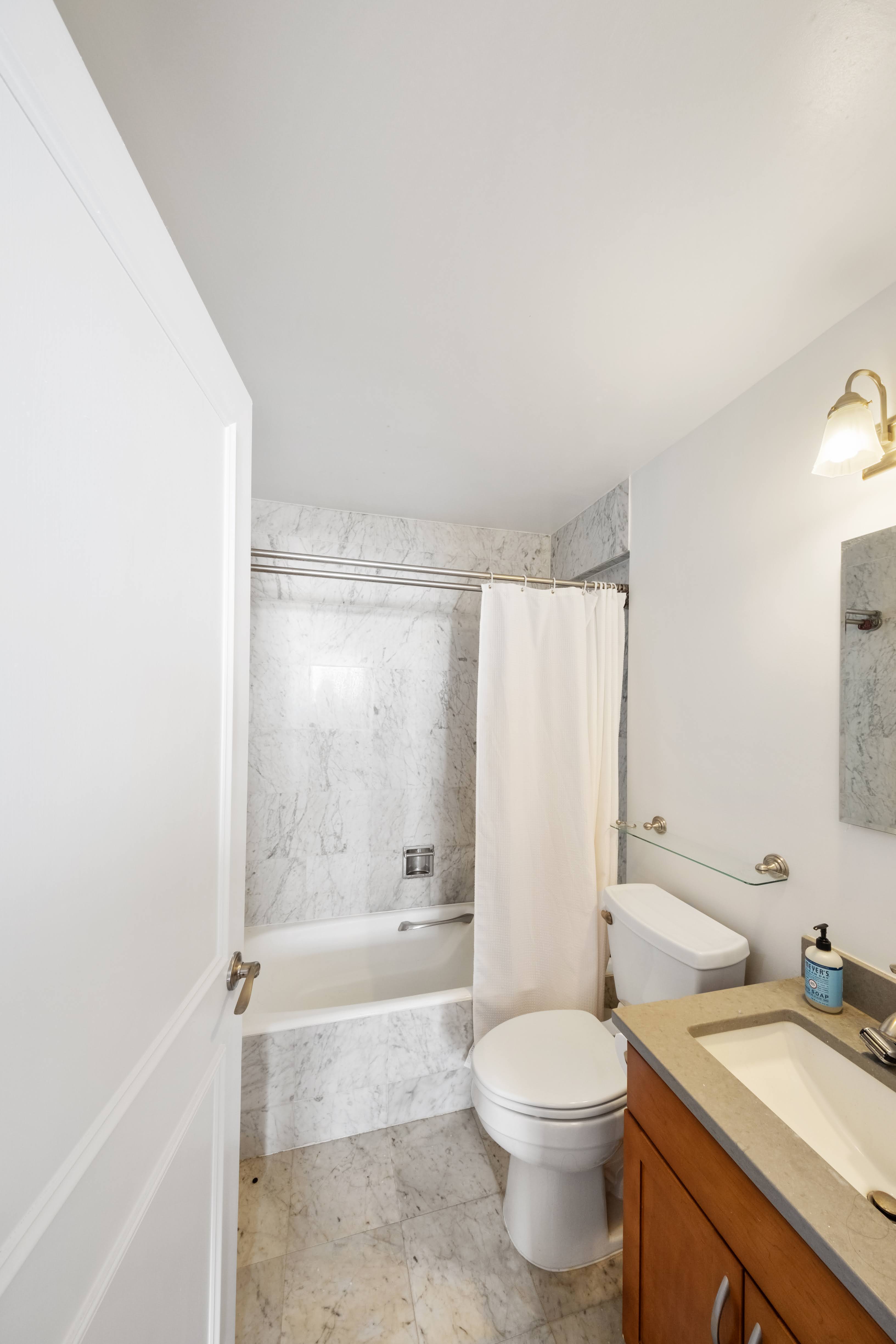 200 Rector Place, Unit 16F Manhattan, NY 10280 - Photo 7 of 25 a bathroom with a granite countertop bathtub sink vanity mirror and toilet