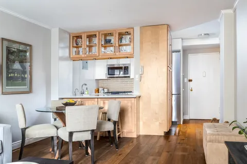 a dining room with a table chairs and a kitchen view