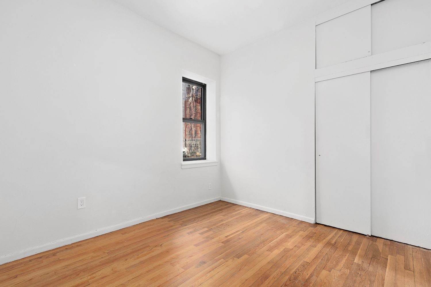 301 East 49th Street, Unit 3AB Manhattan, NY 10017 - Photo 5 of 7 a view of an empty room with wooden floor and a window