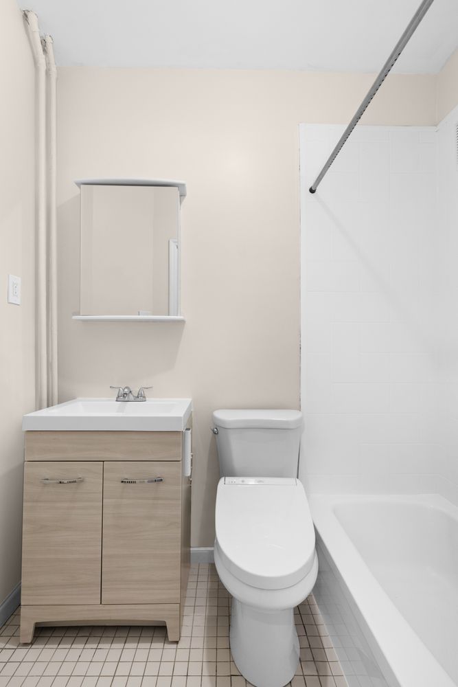 239 Withers Street Brooklyn, NY 11211 - Photo 7 of 14 a bathroom with a sink a toilet and bathtub