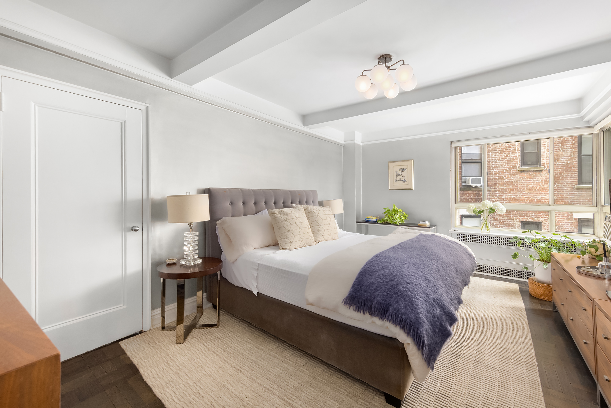 411 West End Avenue, Unit 3B/4B Manhattan, NY 10024 - Photo 8 of 16 a spacious bedroom with a bed and a chandelier