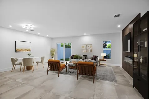 a living room with furniture a large window and stainless steel appliances