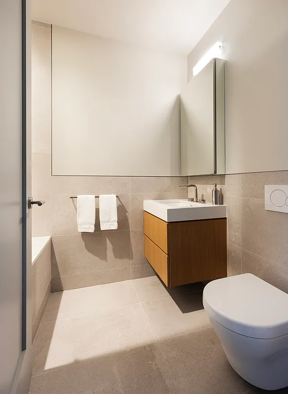1059 3rd Avenue, Unit 25 Manhattan, NY 10065 - Photo 11 of 13 a bathroom with a sink and a mirror