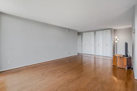 a view of empty room with wooden floor