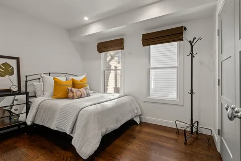 a bedroom with a bed wooden floor and window