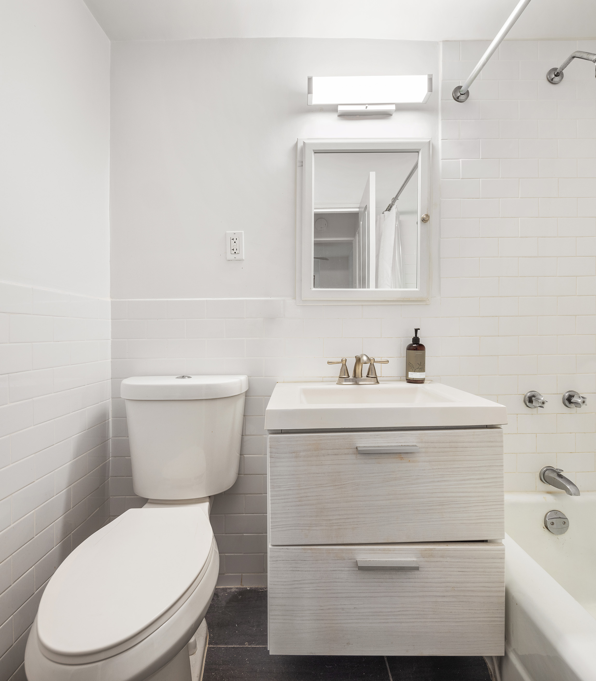 175 West 12th Street, Unit 5M Manhattan, NY 10011 - Photo 6 of 10 a bathroom with a sink a toilet and mirror