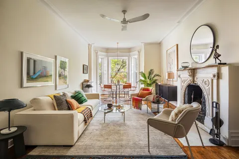 a living room with furniture a large window and a fireplace