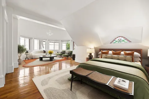 a living room with a couch and potted plant with wooden floor