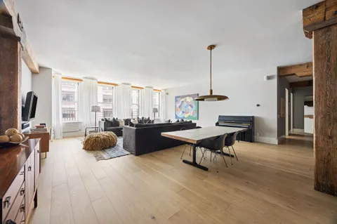 a living room with furniture a flat screen tv and a large window