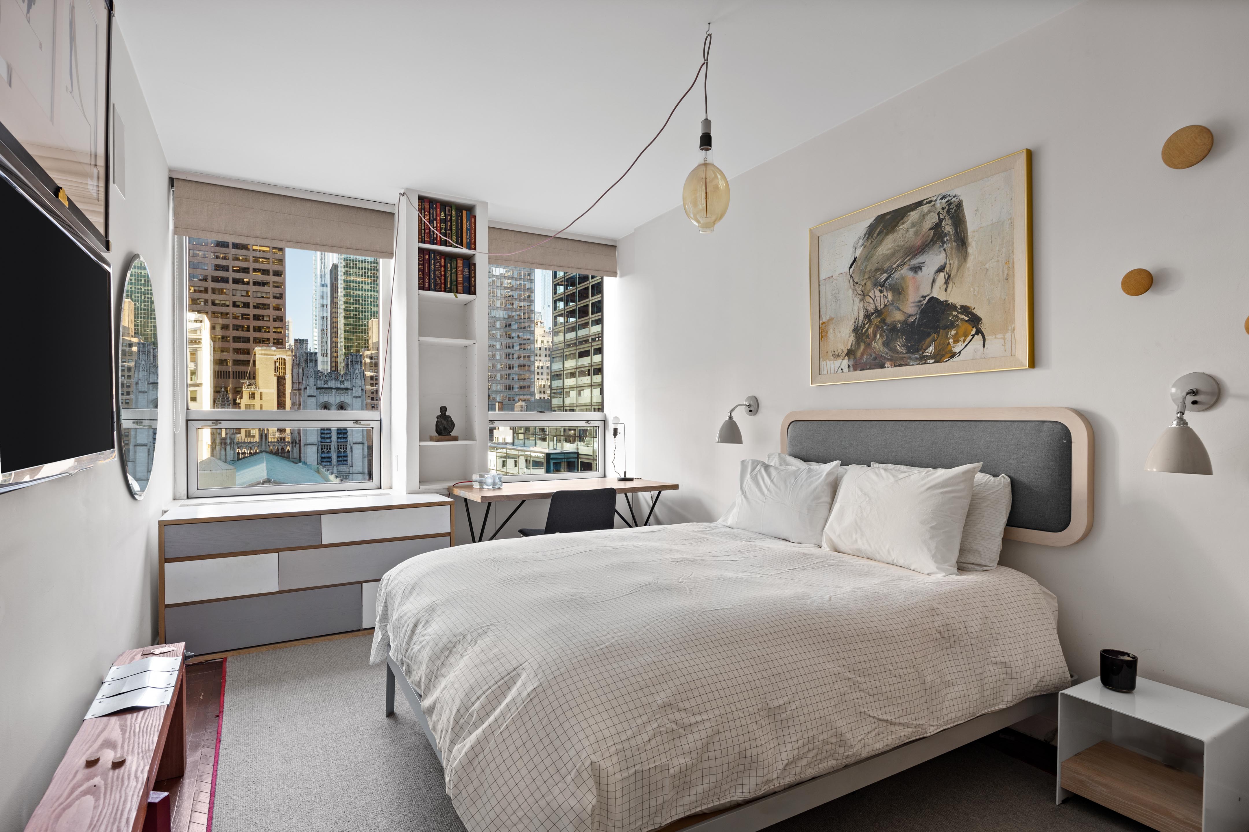15 West 53rd Street, Unit 10H Manhattan, NY 10019 - Photo 5 of 11 a bedroom with a large bed and a large window