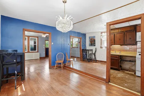 a view of a livingroom with furniture a chandelier and wooden floor