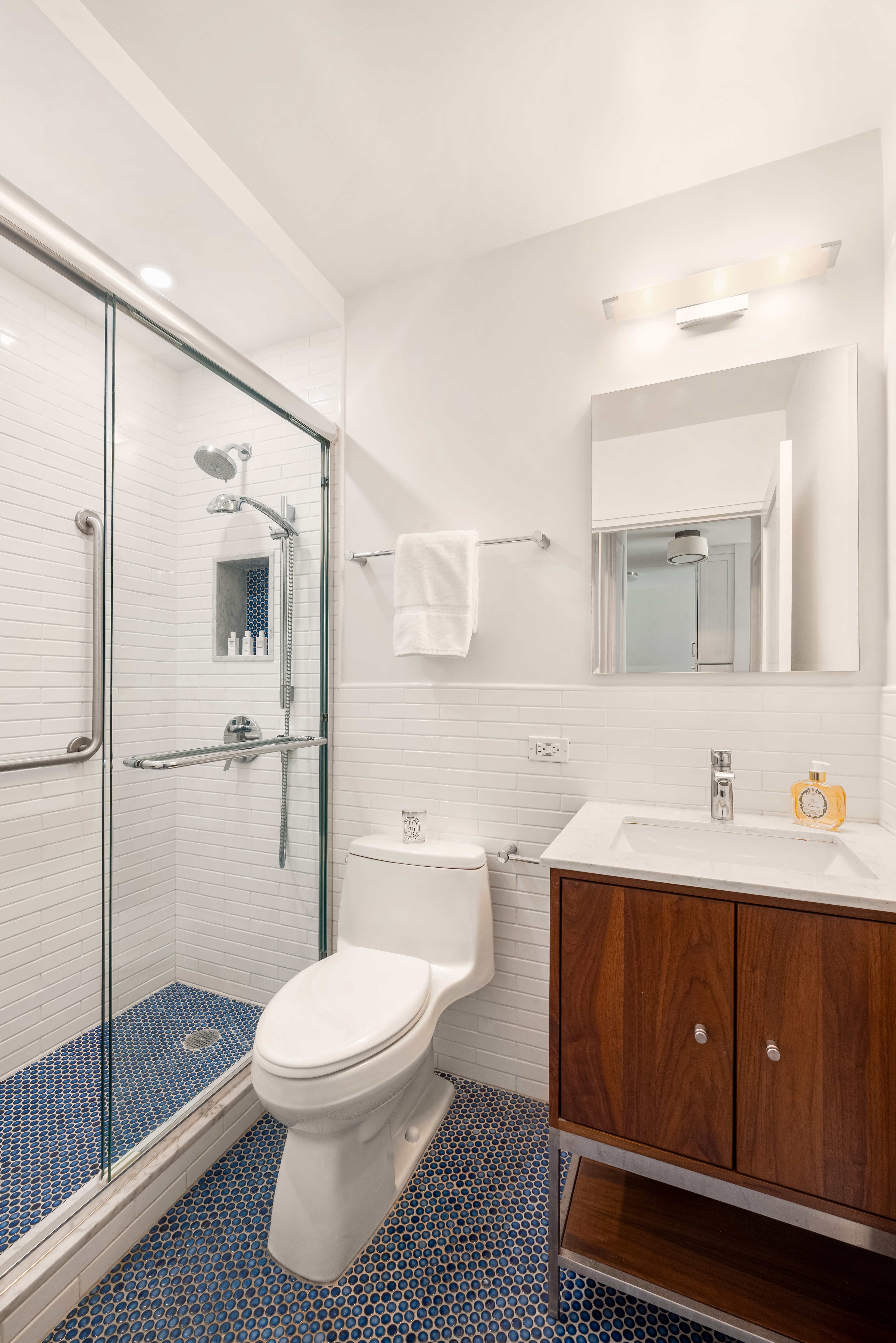 300 East 54th Street, Unit 7B Manhattan, NY 10022 - Photo 5 of 6 a bathroom with a toilet a sink and mirror