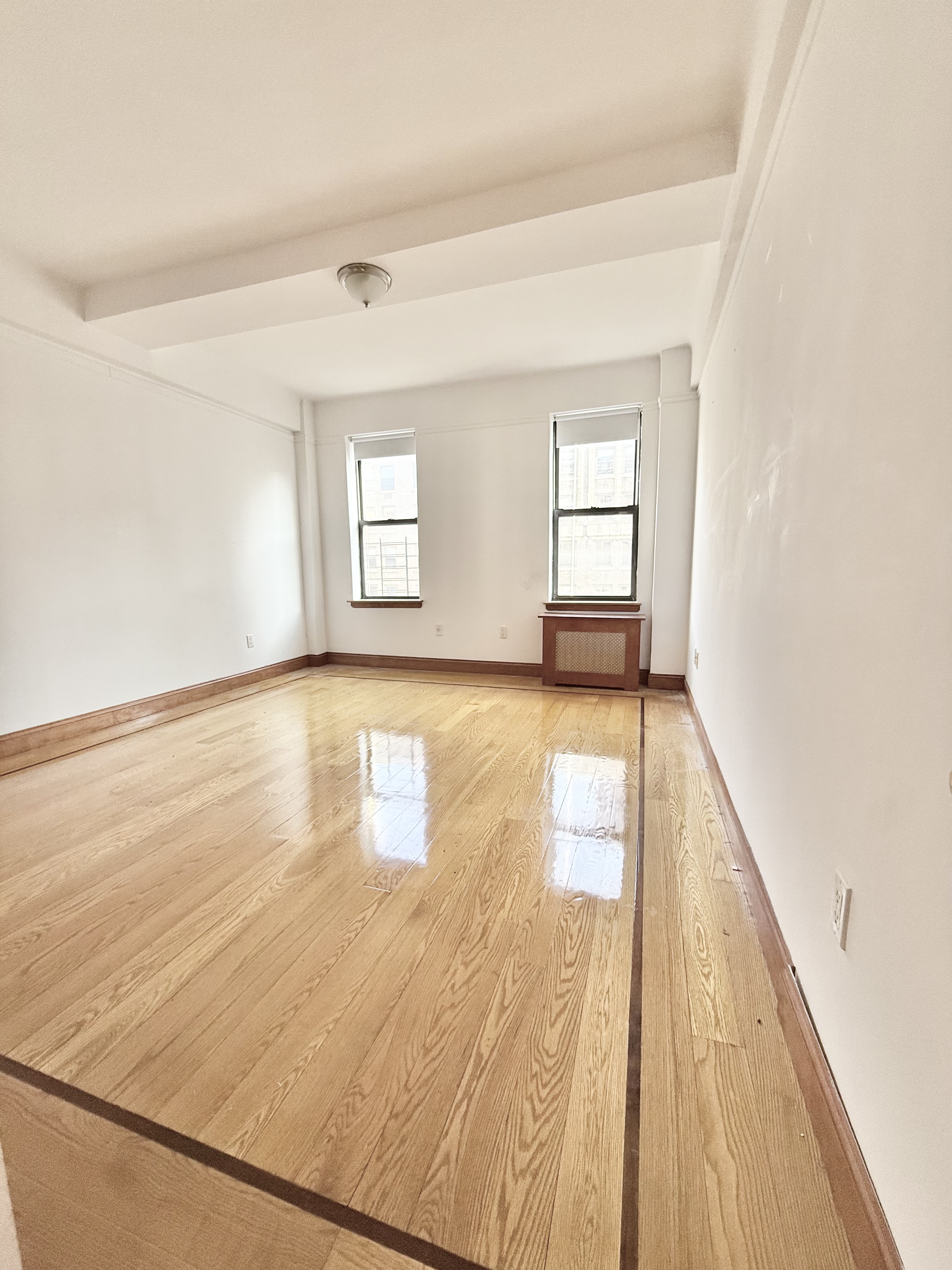 675 West End Avenue, Unit 12A Manhattan, NY 10025 - Photo 7 of 15 an empty room with wooden floor and windows