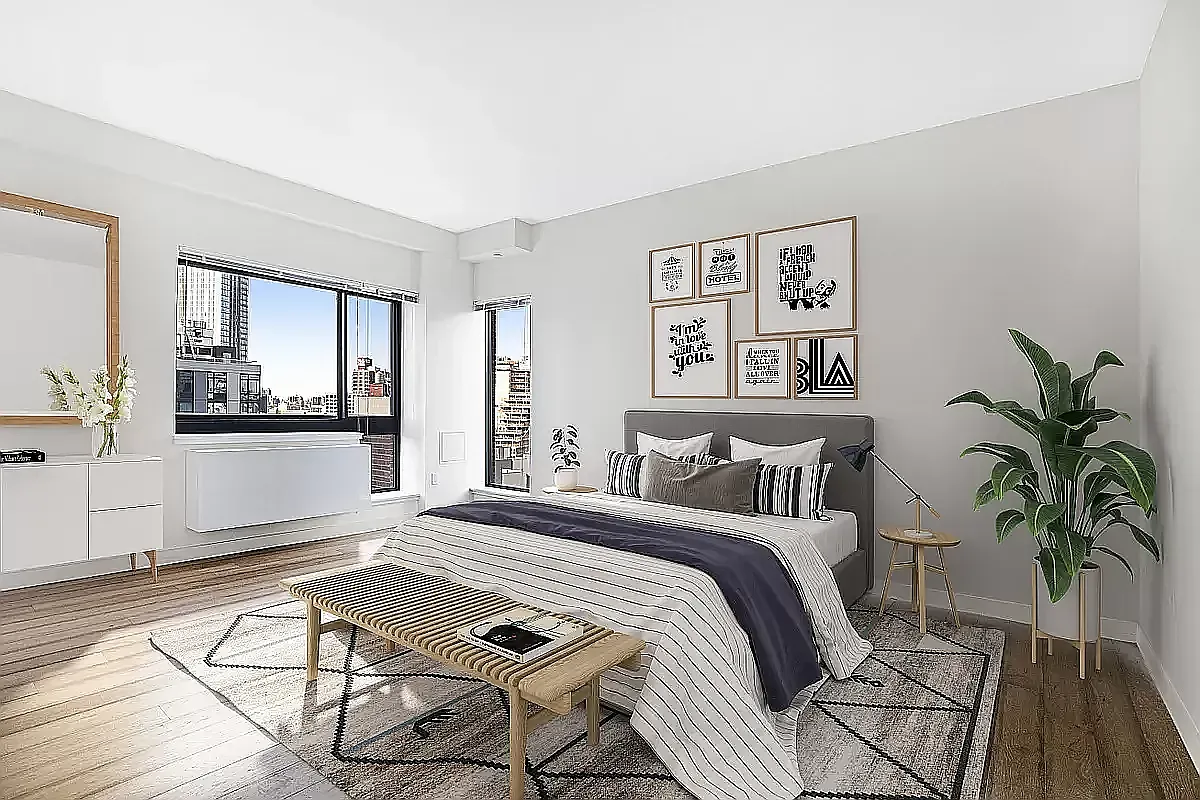 a bedroom with a large bed and a potted plant
