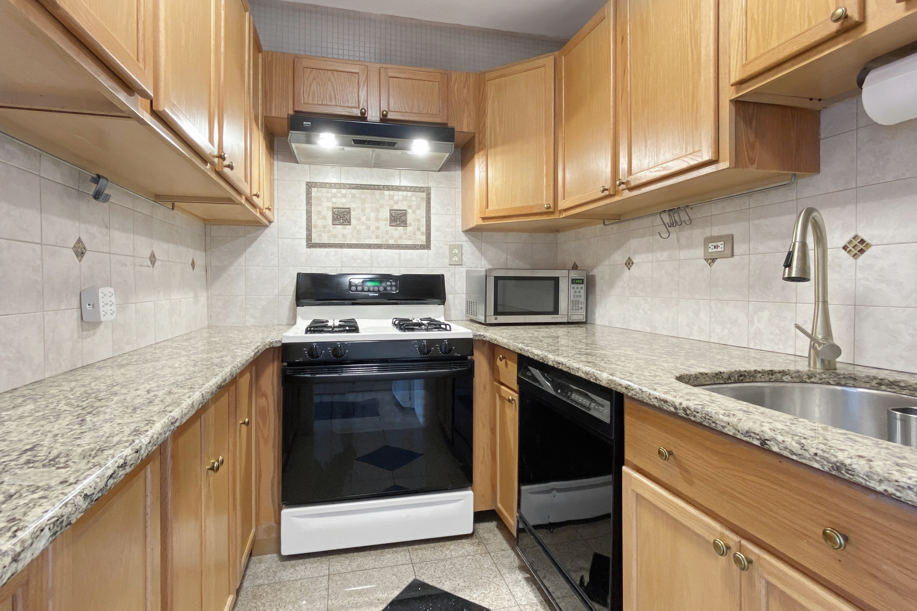 300 East 33rd Street, Unit 9D Manhattan, NY 10016 - Photo 6 of 17 a kitchen with stainless steel appliances granite countertop a stove and a sink