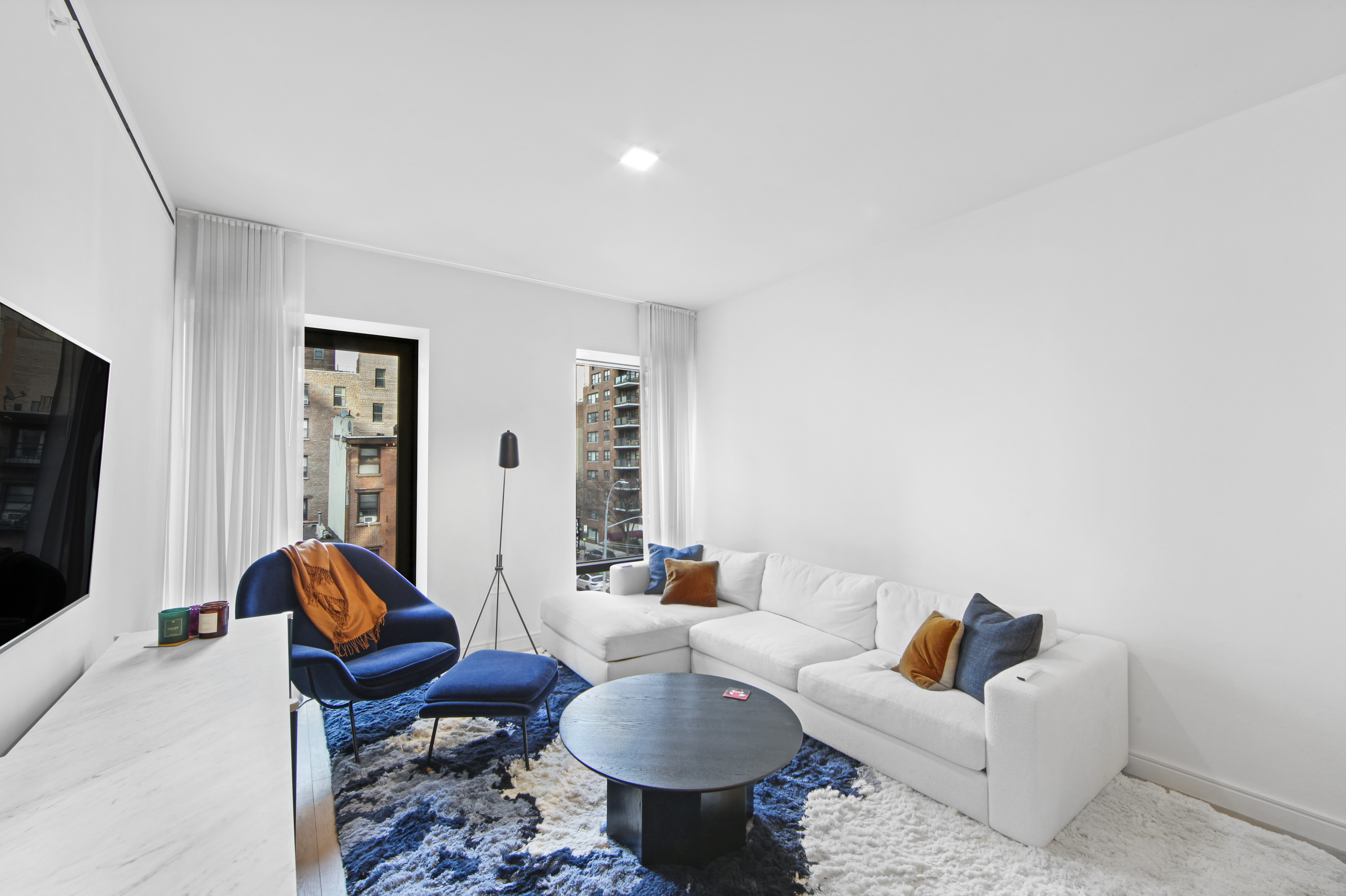 200 East 21st Street, Unit 4B Manhattan, NY 10010 - Photo 4 of 15 a living room with furniture a rug and a flat screen tv