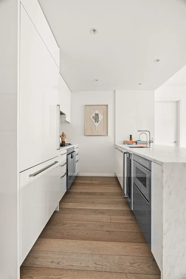 a kitchen with granite countertop a refrigerator and a stove top oven