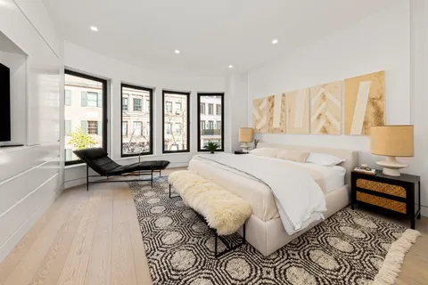 a spacious bedroom with a bed and glass windows