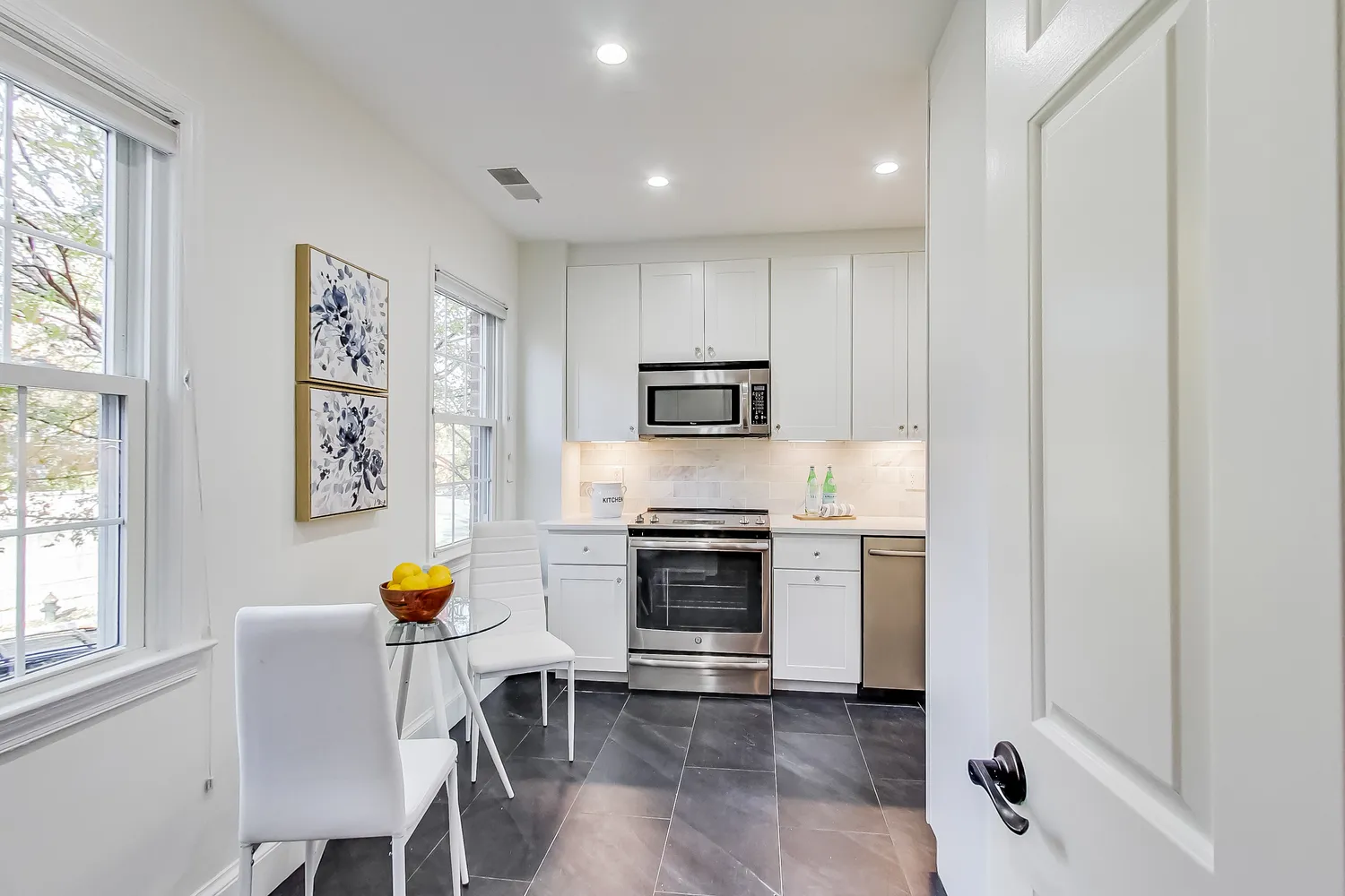 a kitchen with stainless steel appliances a stove a sink cabinets and a window