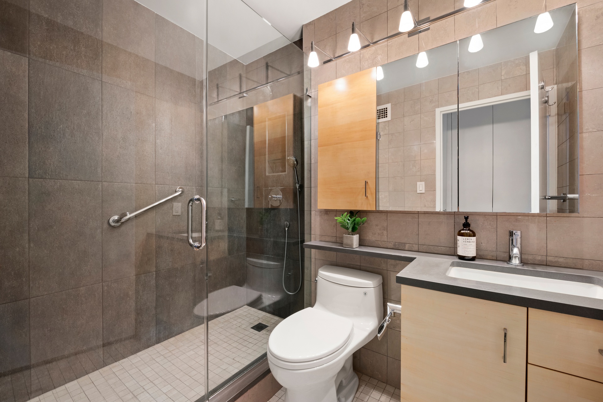 300 East 59th Street, Unit 2103 Manhattan, NY 10022 - Photo 9 of 14 a bathroom with a granite countertop sink toilet and shower