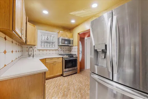 a kitchen with stainless steel appliances a refrigerator sink and stove