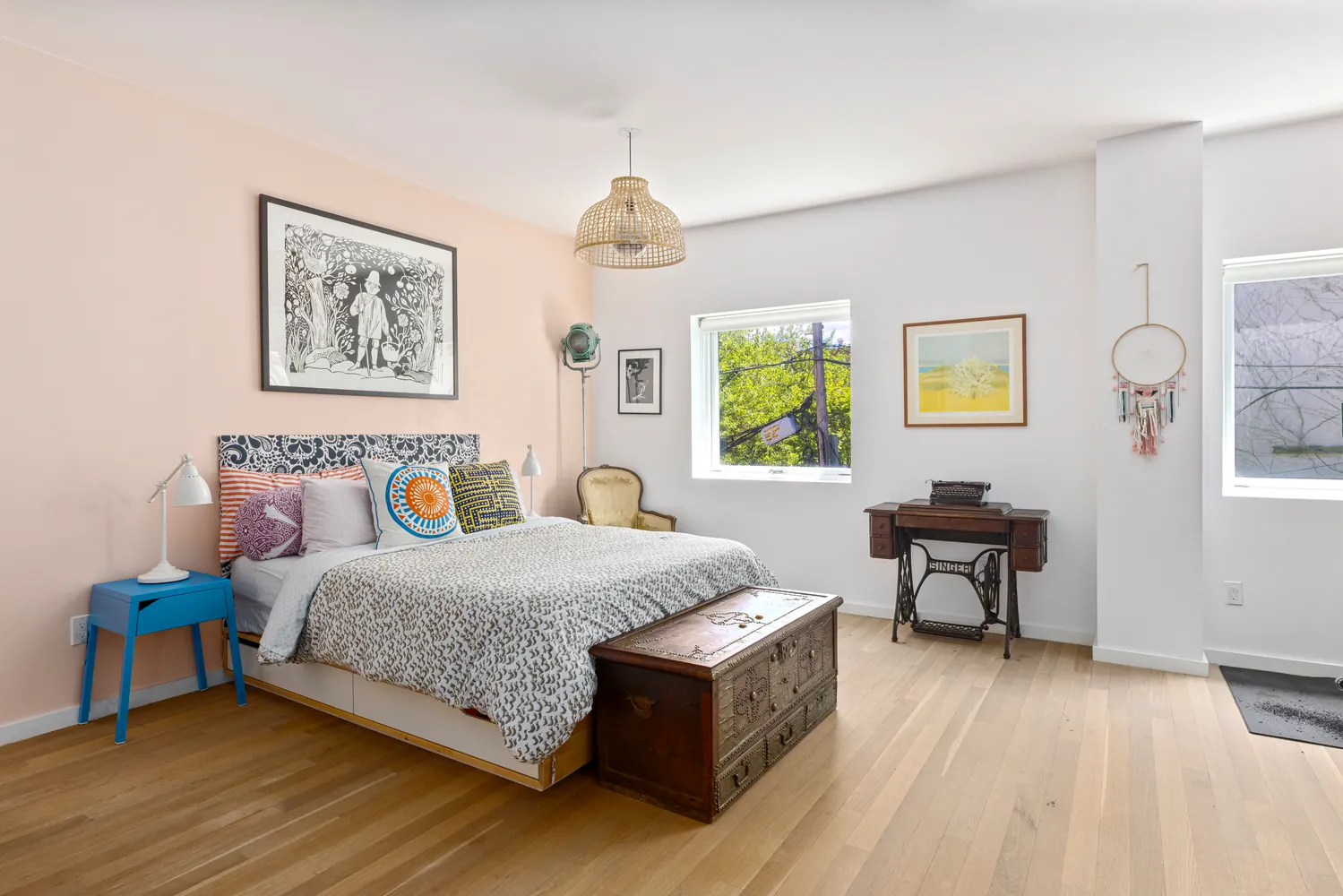 a bedroom with a bed painting on wall and a window