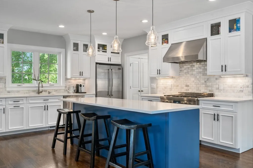 a kitchen with stainless steel appliances a table chairs refrigerator and sink
